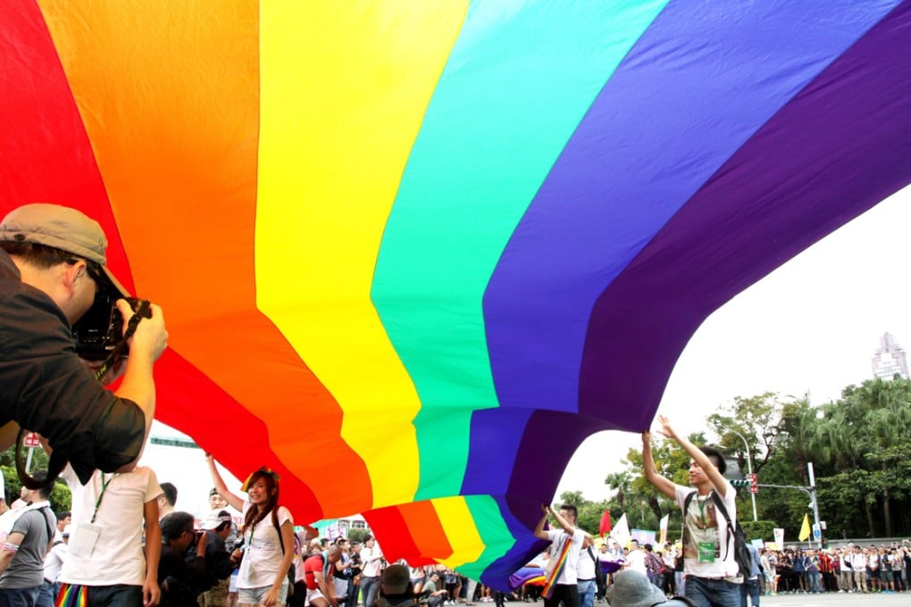 Revellers hold up a giant rainbow flag during the 12th annual Taipei Gay Pride march in Taipei on Saturday. Photo: EPA