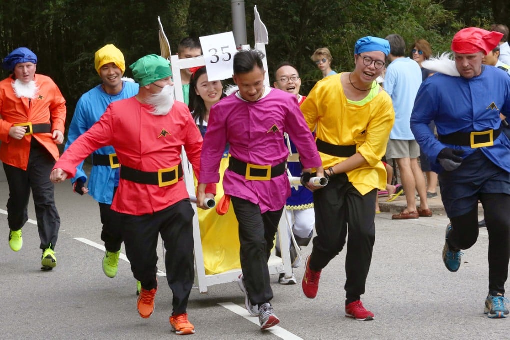 Snow White and the seven dwarfs compete in the Sedan Chair Race on The Peak yesterday. Photo: Jonathan Wong