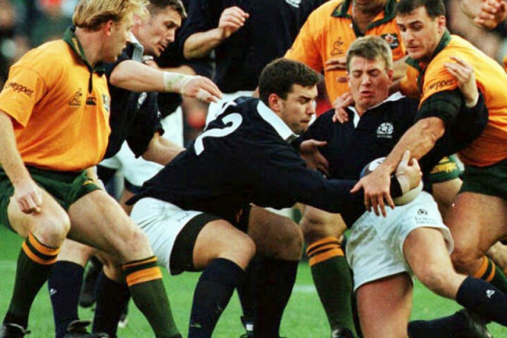 Scotland’s Craig Chalmers (second right) and Ronnie Eriksson (number 12) keep the ball from Australia’s Daniel Herbert during a November 1996 test match at Murrayfield. Chalmers was in Hong Kong last weekend to entertain diners at the HK Scottish Members Luncheon. Photo: AFP