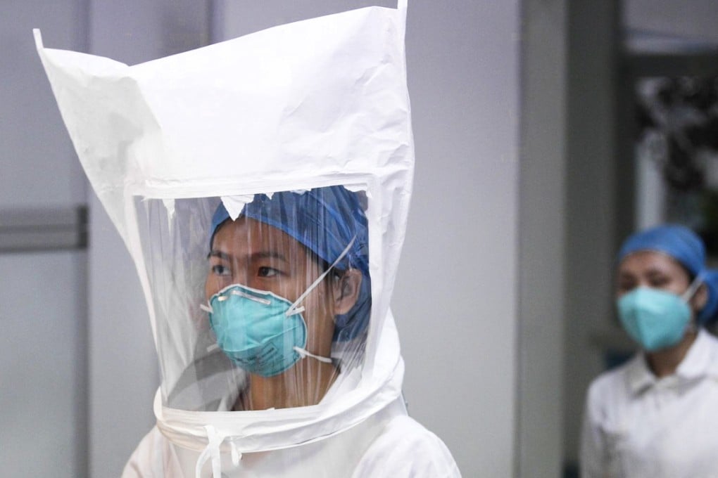 Staff at Shenzhen Third People's Hospital conduct tests on an Ebola protective suit to ensure it has no leaks. Photo: Reuters