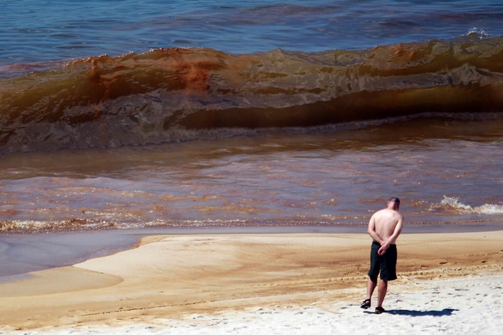 Oil is seen in the water as it washes ashore from the Deepwater Horizon oil spill in the Gulf of Mexico on June 26, 2010 in Orange Beach, Alabama. Photo: AFP