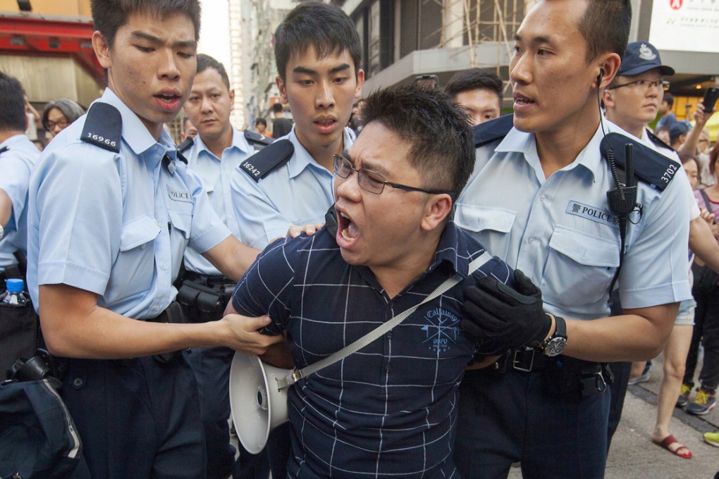 Police officers arrest an alleged anti-Occupy agent provocateur in Mong Kok. Photo: EPA
