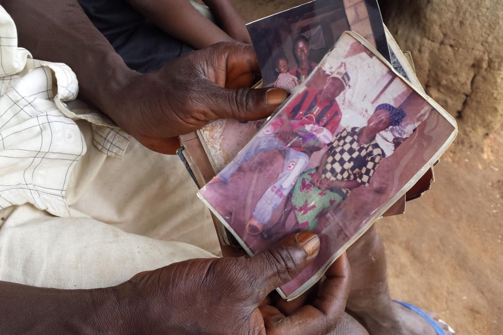 Relatives hold a photo of Emile Ouamouno. Photo: AP