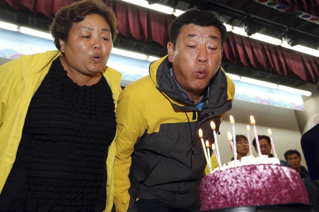 Hwang In-yeol and his wife, Shim Myeong-seop, blow out candles on a birthday cake for their late daughter Ji-hyeon. Photo: AP