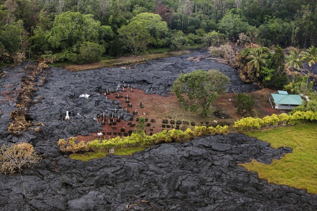 Lava advances through a graveyard near the village of Pahoa on Hawaii Island, which faces the threat of being divided in two. Photo: Reuters