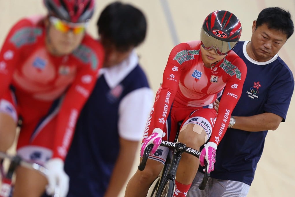 Assistant coach Pu Linjun keeps Sarah Lee steady before the start of the women's sprint against Meng Zhaojuan (front). Photo: Nora Tam