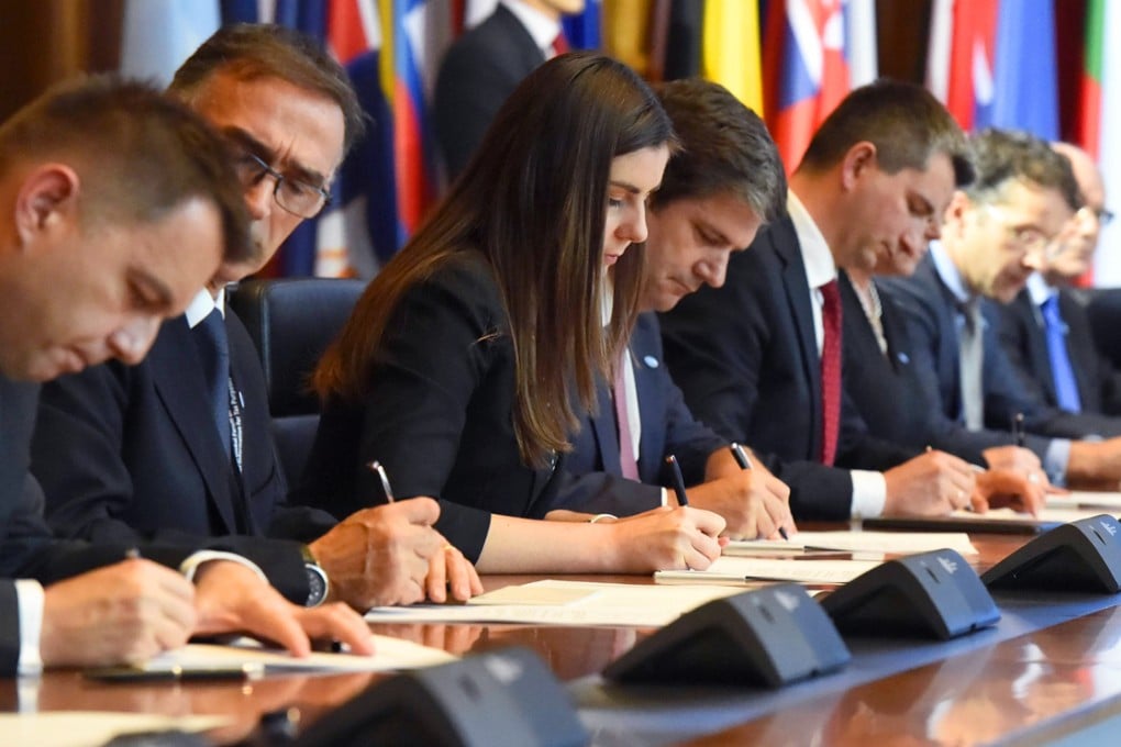 Participants of the Berlin Tax Conference sign the Multilateral Competent Authority Agreement in Berlin. Photo: AFP