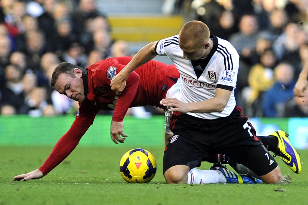 Manchester United's Wayne Rooney and Fulham's Steve Sidwell vie for the ball. Photo: EPA