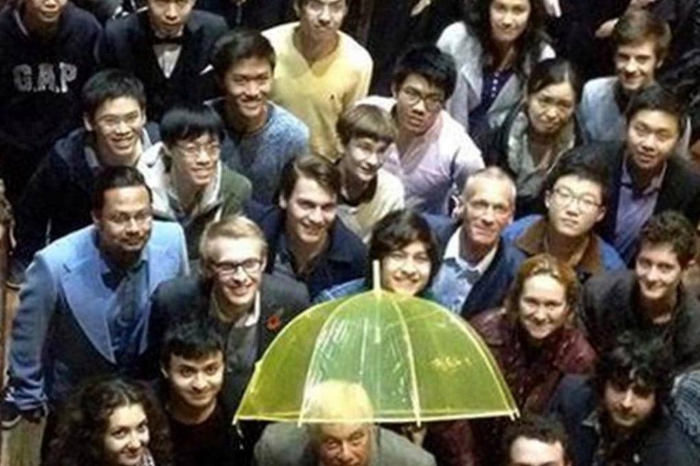 Chris Patten holds a yellow umbrella at Oxford University.