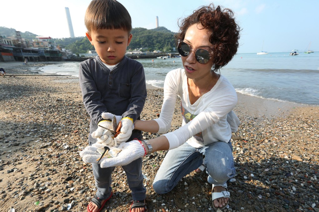 Tak Cheng, three, of Banyan House preschool and his mother, Maeve Cheng, participate in a clean-up at Yung Shue Wan beach. Photo: Nora Tam