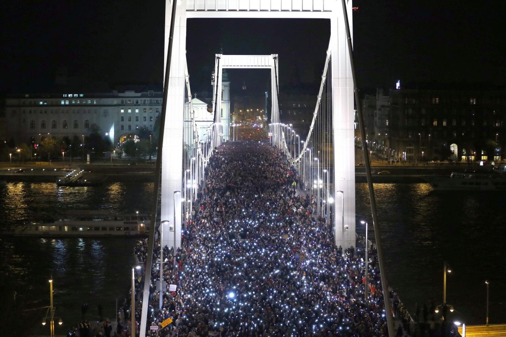 Tens of thousands of Hungarians hold up their mobiles during a protest in Budapest against the proposed tax. Photo: Reuters