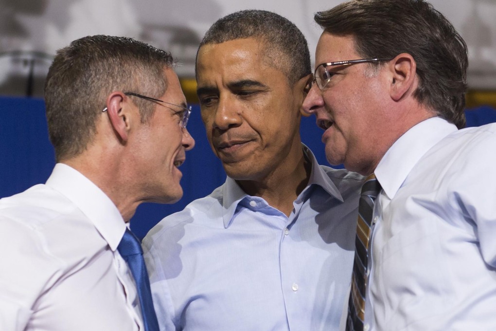President Barack Obama talks to Democratic candidates Mark Schauer (left) and Gary Peters at the weekend rally in Detroit. Photo: AFP