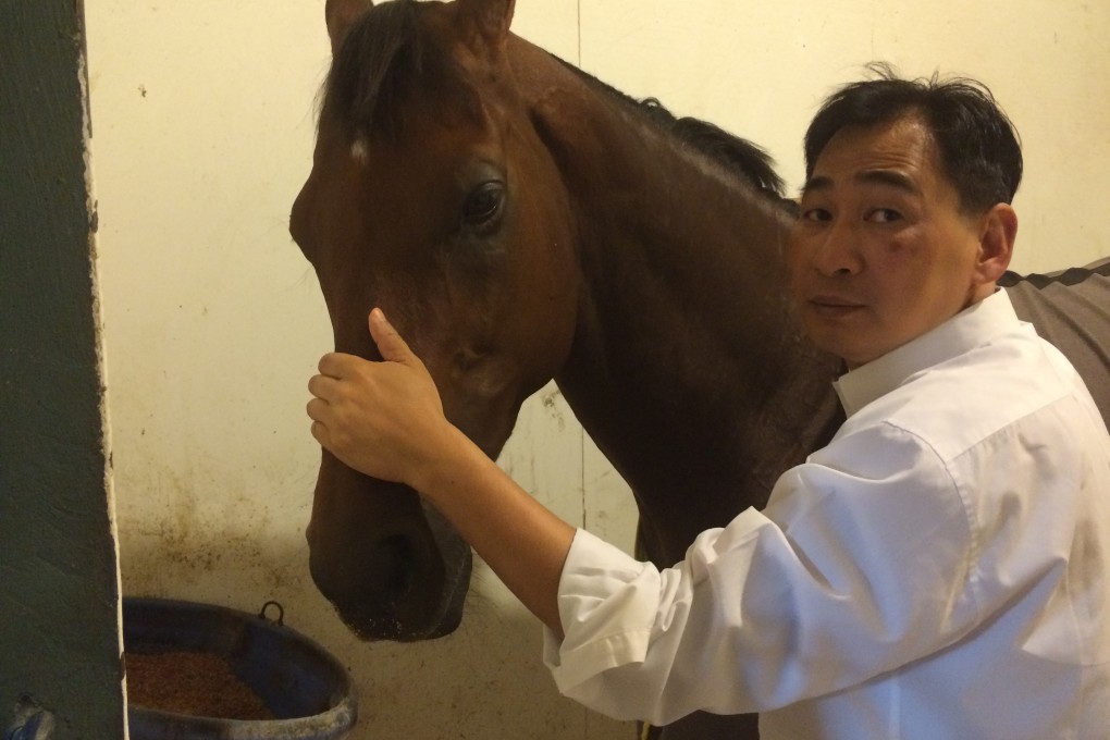 A concerned Michael Chang with Rich Tapestry in the stable after the race. Photo: SCMP Pictures