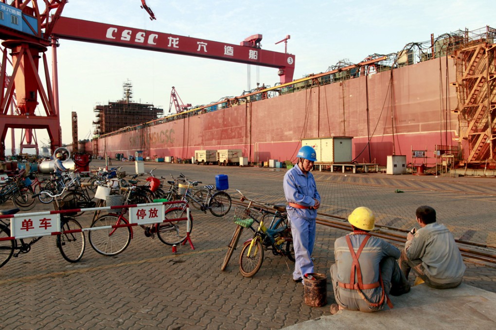 Workers take a break near a ship under construction at CSSC's Longxue Shipyard in Guangzhou.