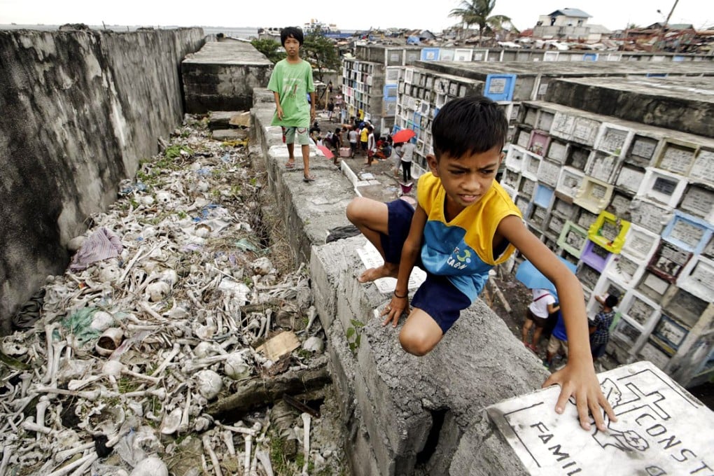 Children play near human bones in a Manila cemetery. Photo: EPA