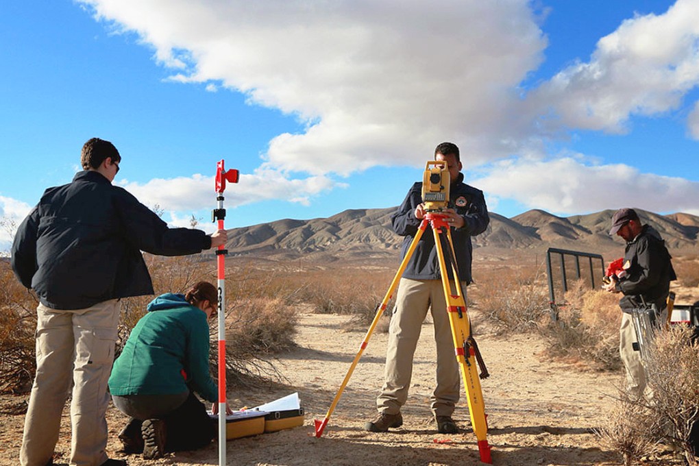 Agents from the NTSB and the FBI survey the debris from SpaceShipTwo out in a desert field near to the crash site. Photo: AFP