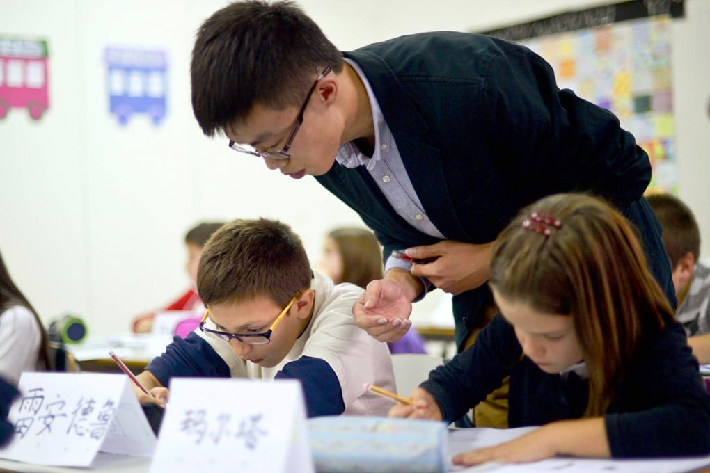 Wang Xinliang helps his class with their new language. Photo: AFP