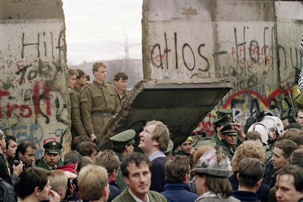 West Berliners gather as East German border guards demolish a section of the wall. Photos: AFP, Tilman Brembs