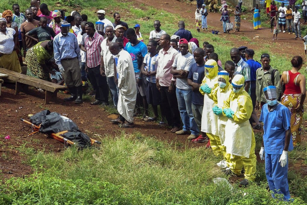 Health workers deal with the body of man suspected to have died of Ebola in Liberia, one of the worst affected countries. Photo: AP