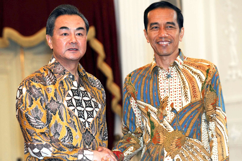 Indonesian President Joko Widodo (right) shakes hands with Chinese Foreign Minister Wang Yi in Jakarta. Photo: Xinhua