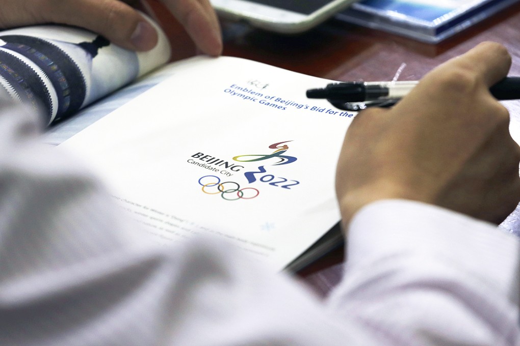 Journalists gather near the Beijing's bid for the 2022 Winter Olympics logo after attending a media briefing by Chinese officials in Beijing. Photo: AP