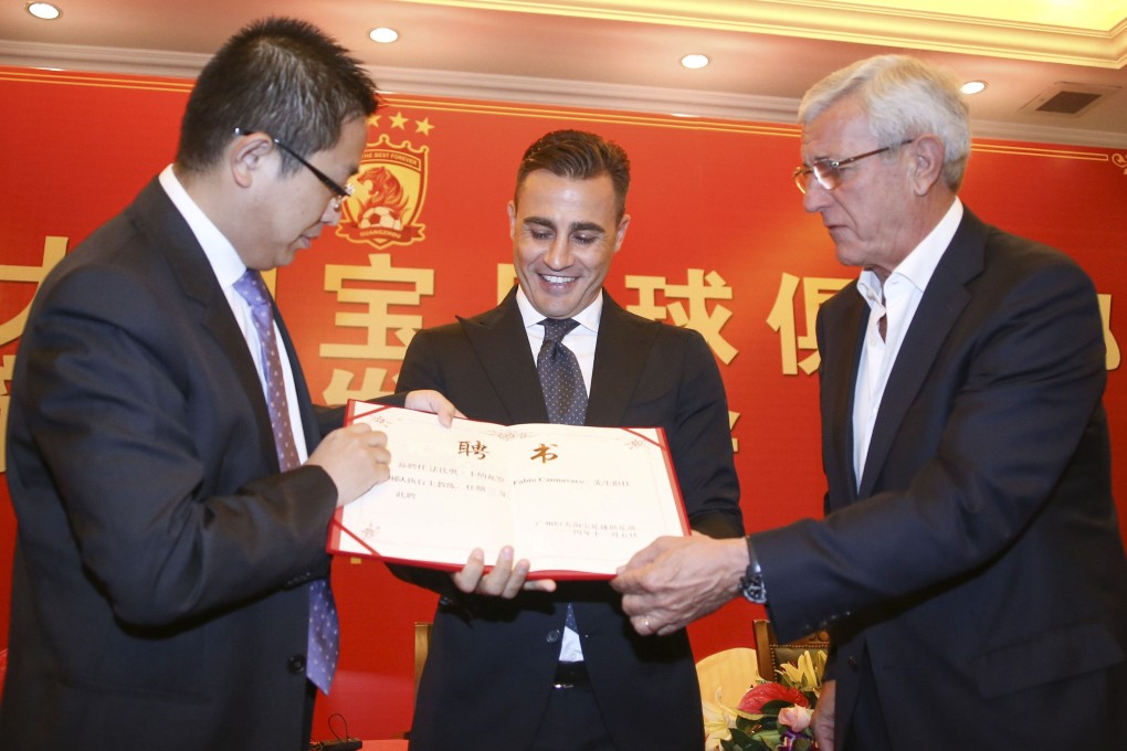 Fabio Cannavaro receives the appointment letter from Liu Yongzhuo, vice-president of Guangzhou Evergrande, and his predecessor Marcello Lippi. Cannavaro will become executive head coach of the Chinese Super League champions. Photo: Reuters