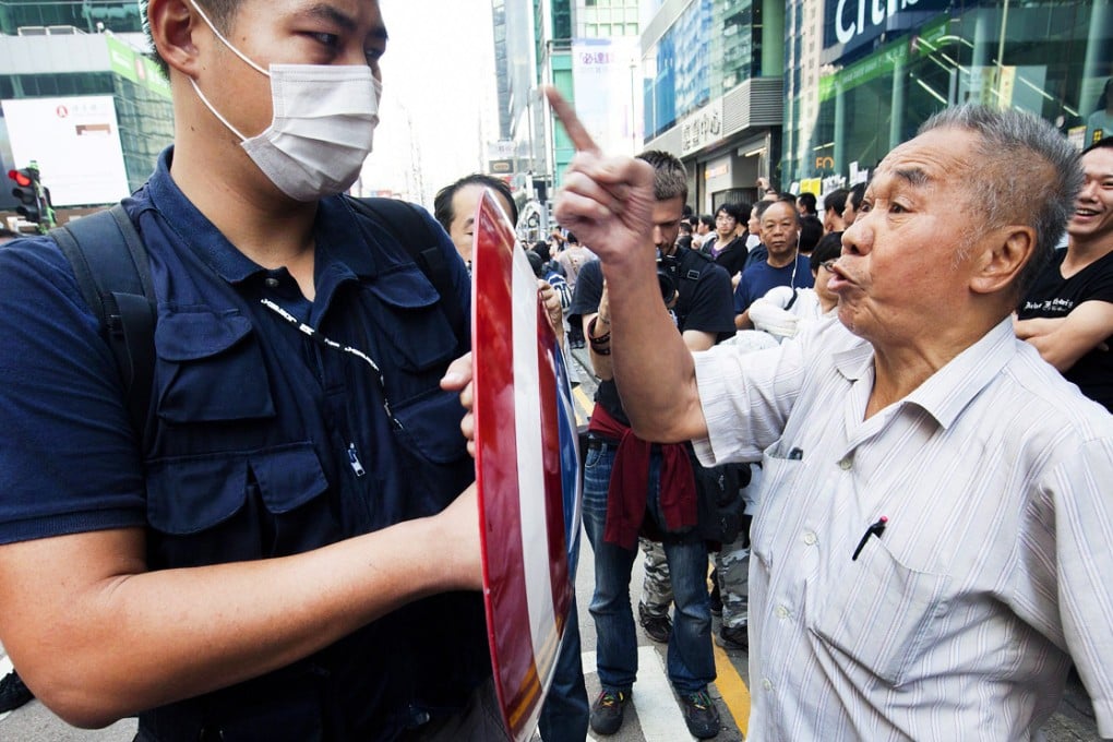 An elderly anti-Occupy protester (right) faces off with an pro-democracy protester in Mong Kok. Photo: EPA