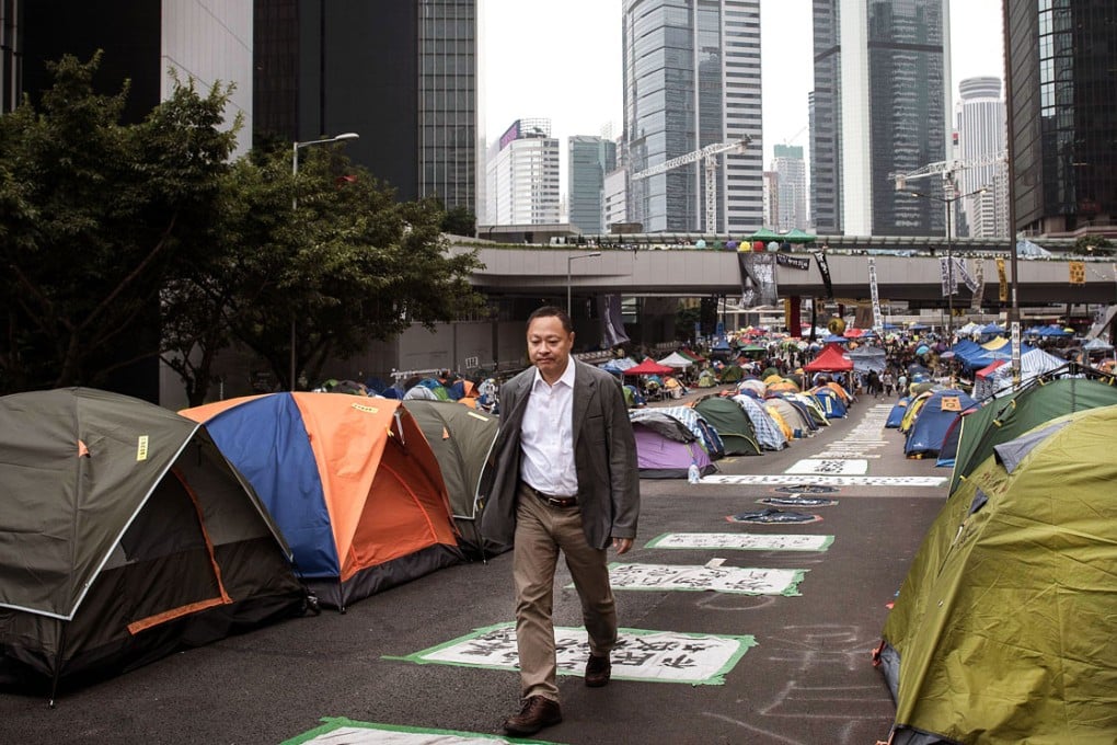 Occupy Central co-founder Benny Tai Yiu-ting (left) walks past tents at the protest site at Admiralty. Photo: AFP