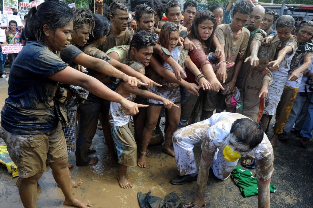 Filipino protesters daubed with mud stage a play in Manila highlighting the slow government response to Typhoon Haiyan. Photo: AFP