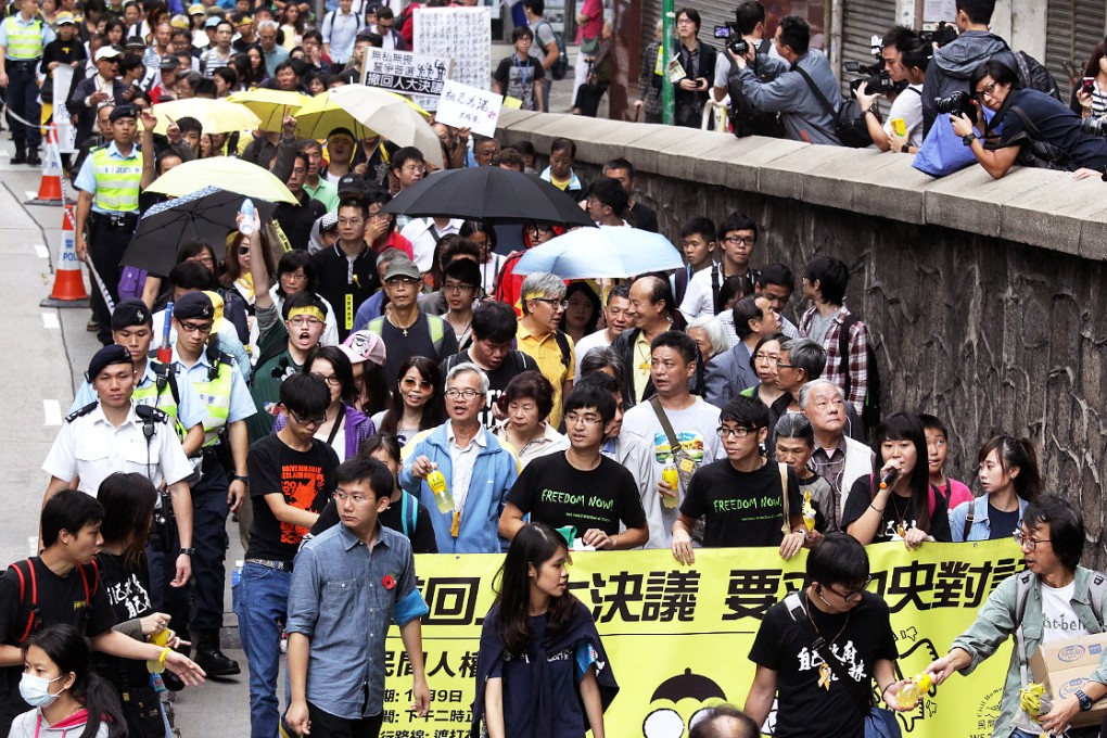 Pro-democracy protesters wearing yellow umbrellas and ribbons make their way from Central to Sai Wan. Photo: Dickson Lee