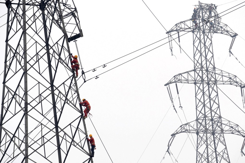 File photo of workers carrying out repairs on a power transmission tower in Zhejiang province, China. Photo: Reuters