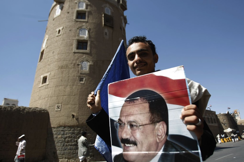 A supporter of Yemen's ousted President Ali Abdullah Saleh holds his picture during a demonstration in Sanaa, Yemen. Photo: AP