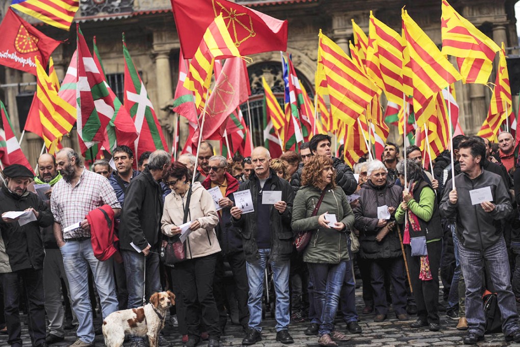 Independence supporters from Catalonia and the Basque country raise their regional flags in Pamplona, northern Spain, yesterday. Photo: AP