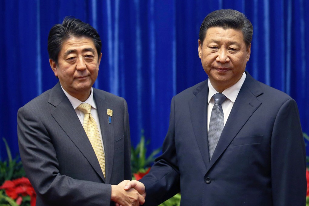 Tension shows on the faces of Shinzo Abe and Xi Jinping as they shake hands at their meeting in the Great Hall of the People. Photo: Reuters