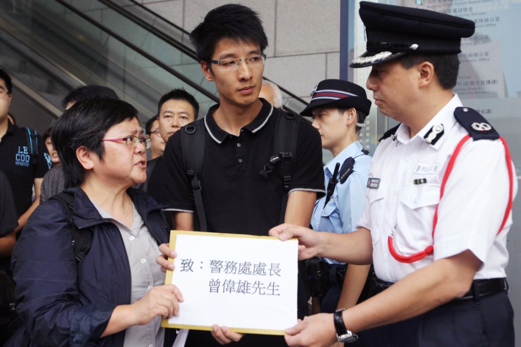 Erik Mak (centre) hands a petition to police last month in a protest against violent attacks on journalists by anti-Occupy Central protesters. Photo: Edward Wong