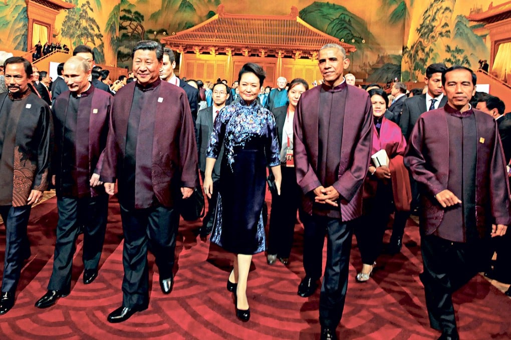 President Xi Jinping, his wife Peng Liyuan, US President Barack Obama and other leaders stride out in their Chinese-style Apec costumes during the summit in Beijing. Photo: AFP