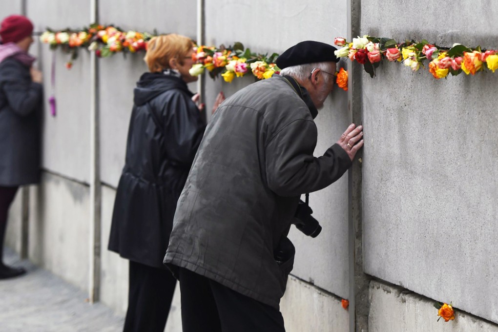 Visitors at a preserved segment of the Berlin Wall. Photo: AFP