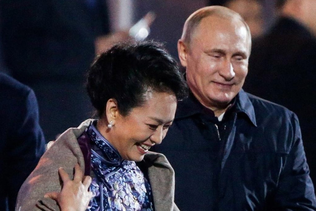 Vladimir Putin puts a blanket around Peng Liyuan. Photo: AP