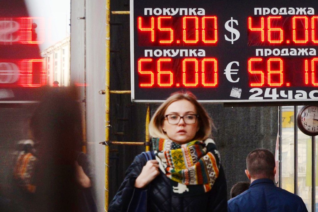 Foreign currency rates against the rouble are listed in a Moscow street. The rouble has hit a record low against the US dollar. Photo: AFP