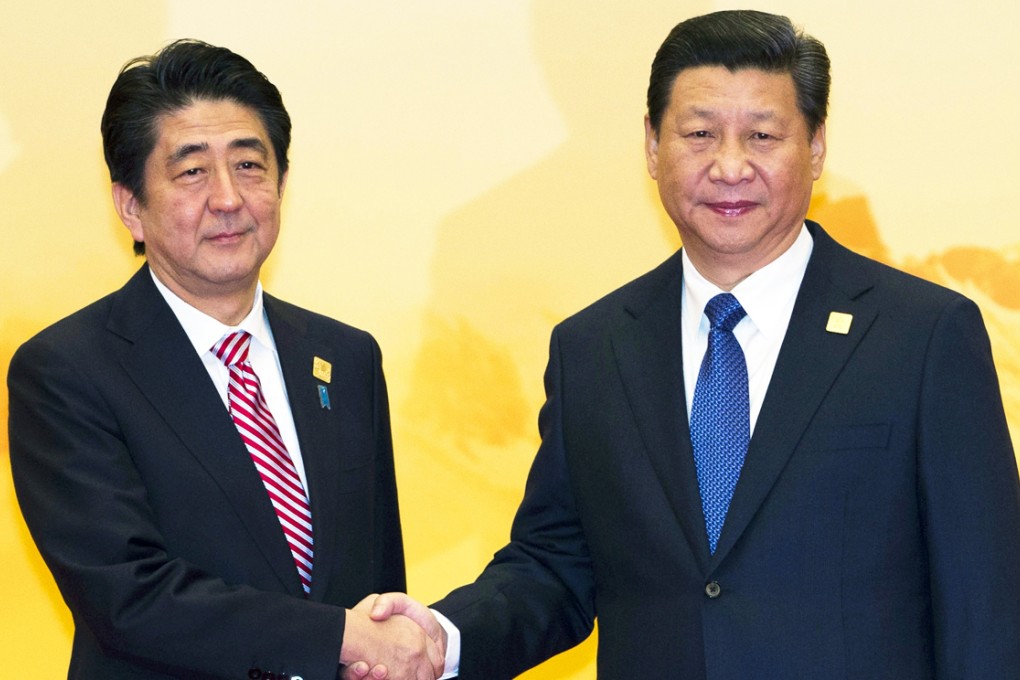 Japan's Prime Minister Shinzo Abe shakes hands with Chinese President Xi Jinping during the Apec summit in Beijing. Photo: AP
