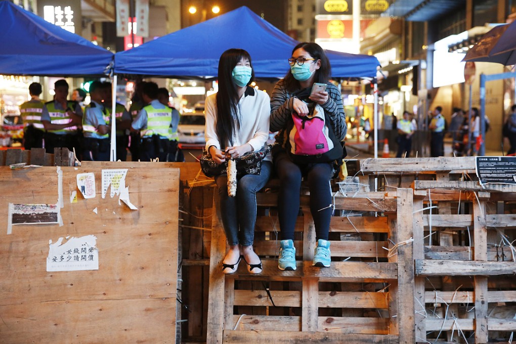 Pro-democracy protesters sit on a barricade in Mong Kok. Photo: AP