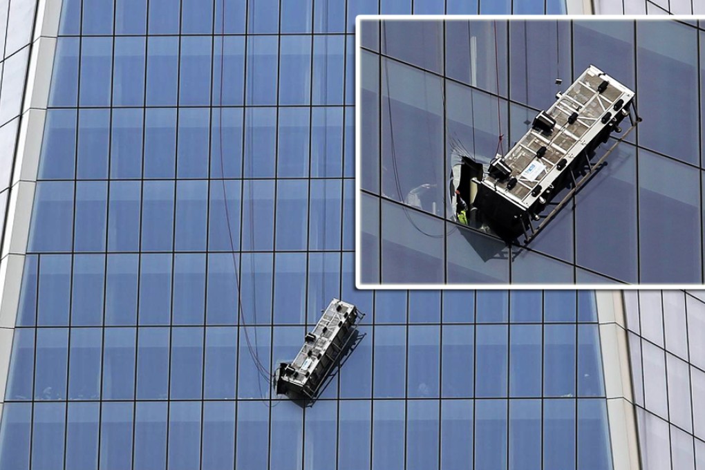 Window washers hang from the side of the World Trade Centre. Photos: AFP