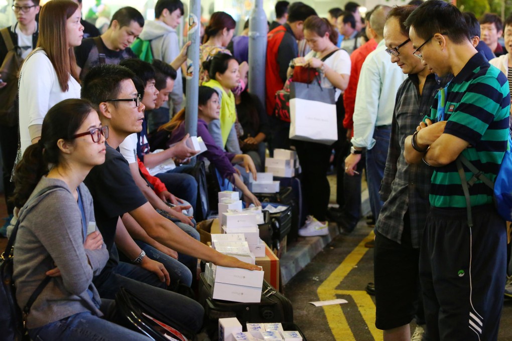 Potential buyers look at what's on offer from iPhone hawkers outside the Causeway Bay Apple store. Photo: Edmond So
