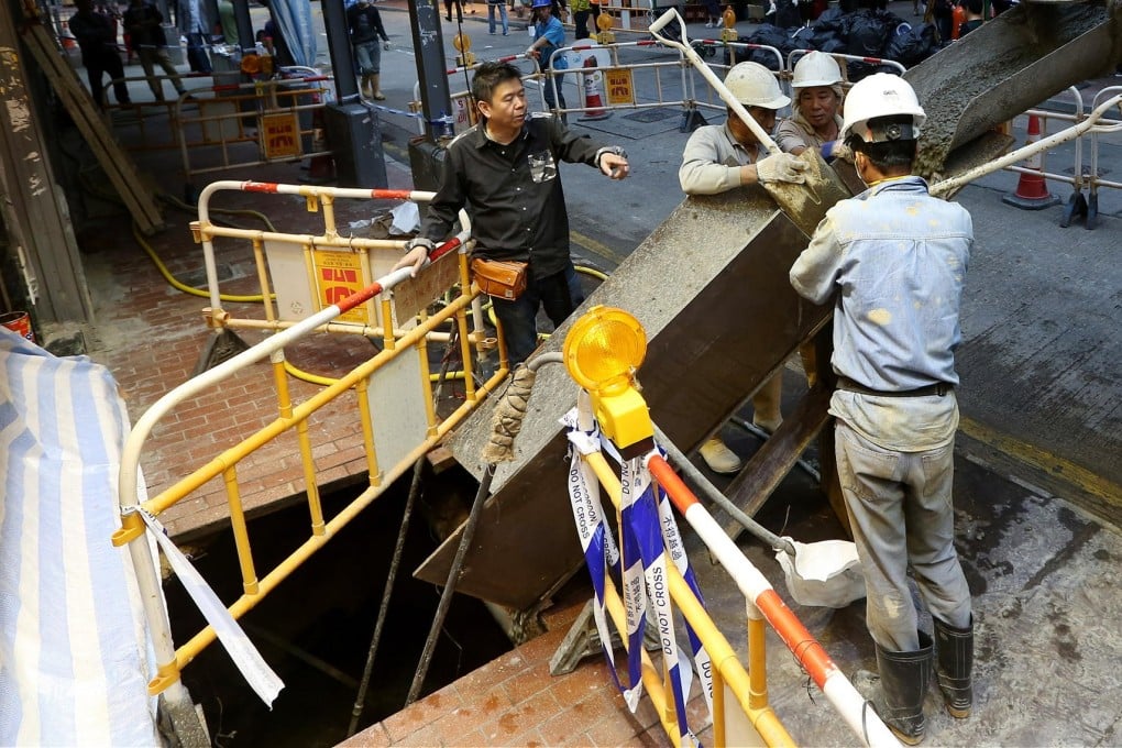 Repair workers prepare to fill the hole with cement. Photo: Sam Tsang