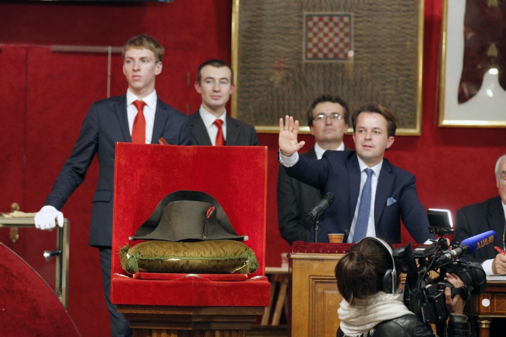 Jean Pierre Osenat (right) takes bids on the bicorne hat in Fontainebleau as part of an auction of Napoleon memorabilia. Photo: AP