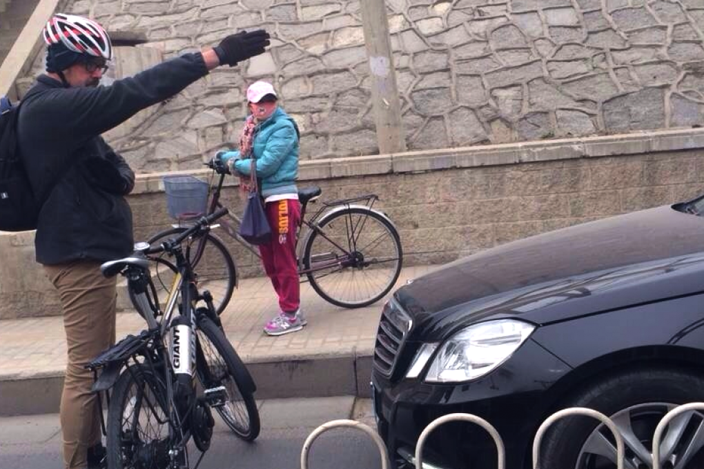 A Beijing cyclist gestures at a car illegally using the designated bike lane. Photo: Weibo