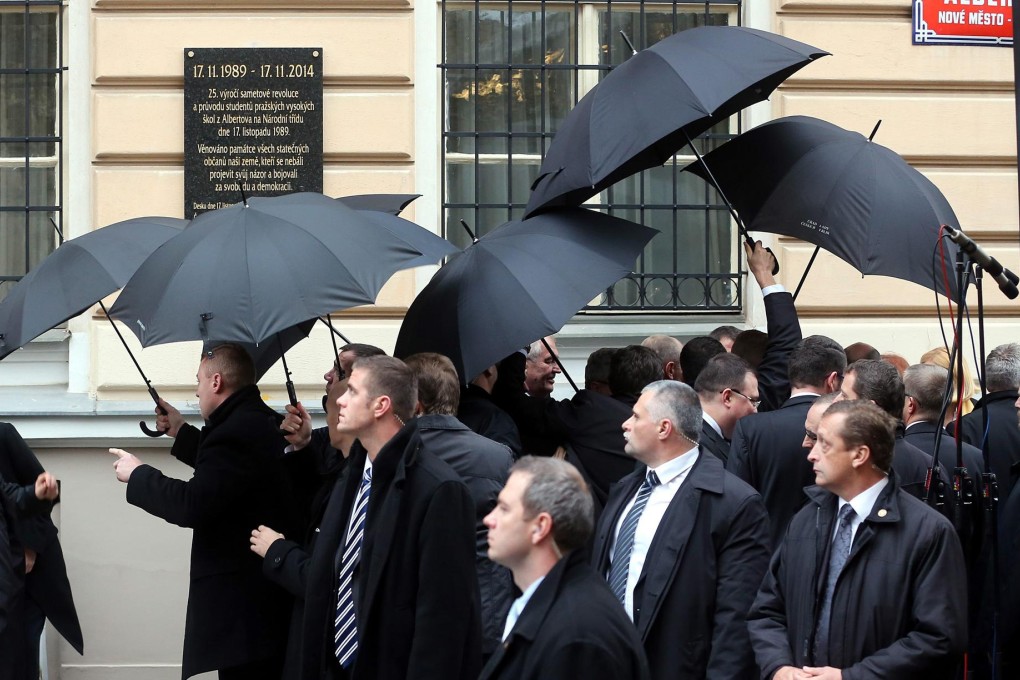 Security officers wield umbrellas to protect President Milos Zeman and foreign leaders who were pelted with eggs and tomatoes. Photo: EPA