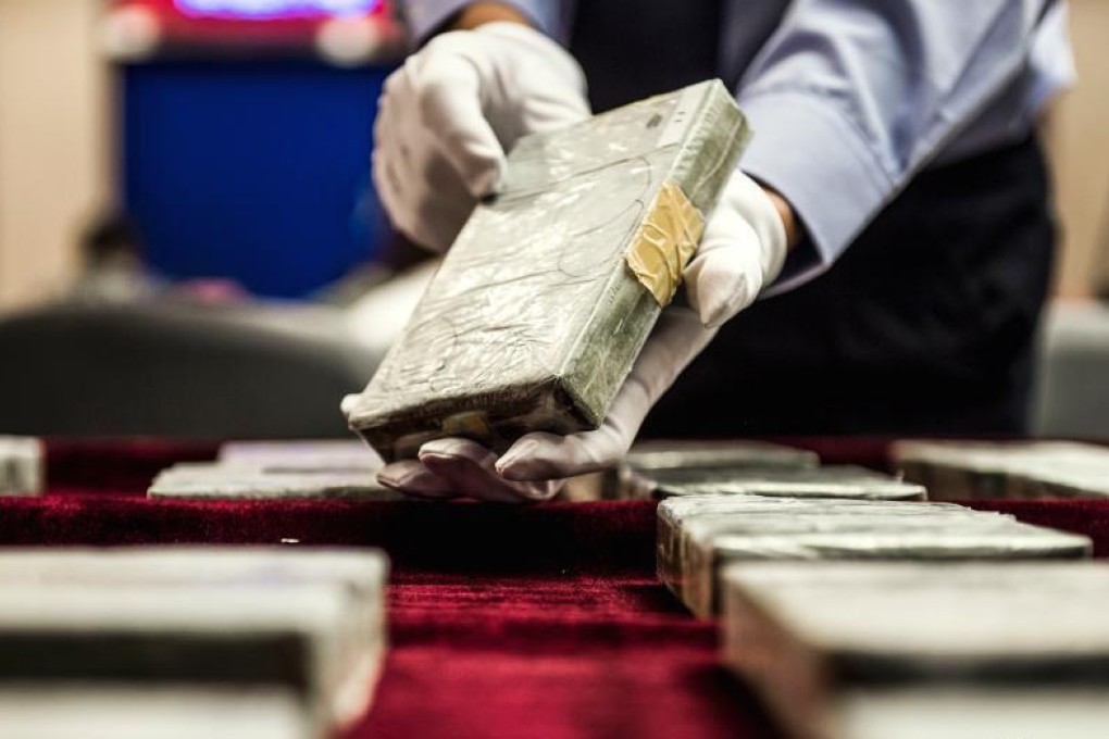 A police officer shows bags of heroin seized in a crackdown during a press briefing in Guangzhou, Guangdong province on November 18, 2014. Photo: CNS