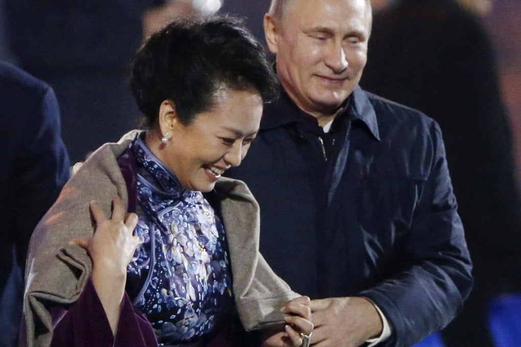 Vladimir Putin puts a shawl on Peng Liyuan. Photo: AP