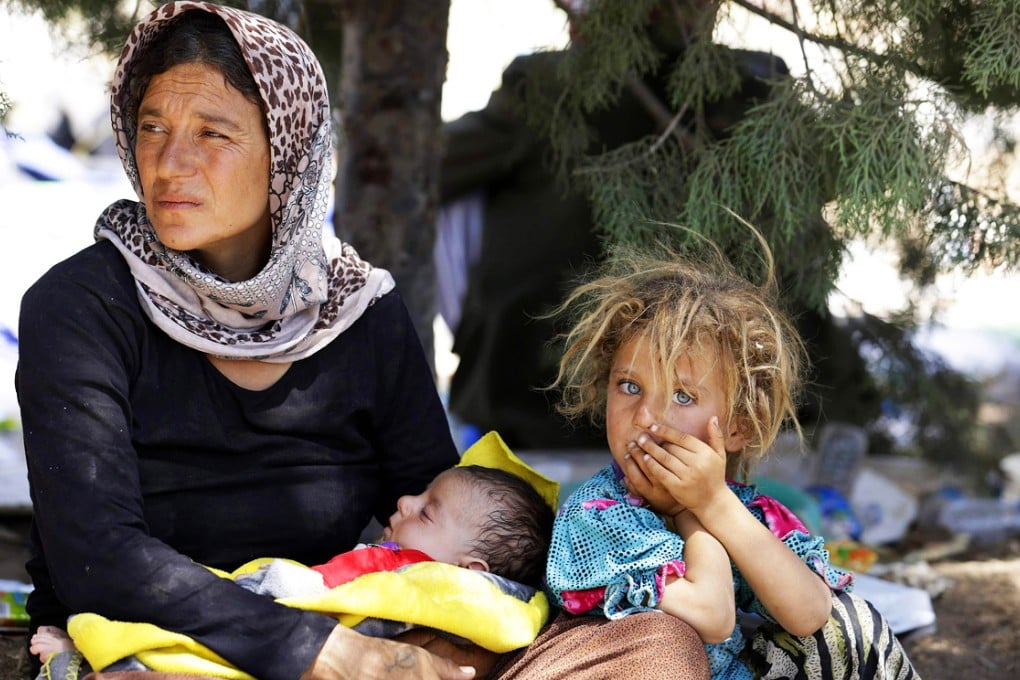 A displaced Yazidi family awaits food at the Iraqi-Syrian border crossing of Fishkhabour. Photo: Reuters